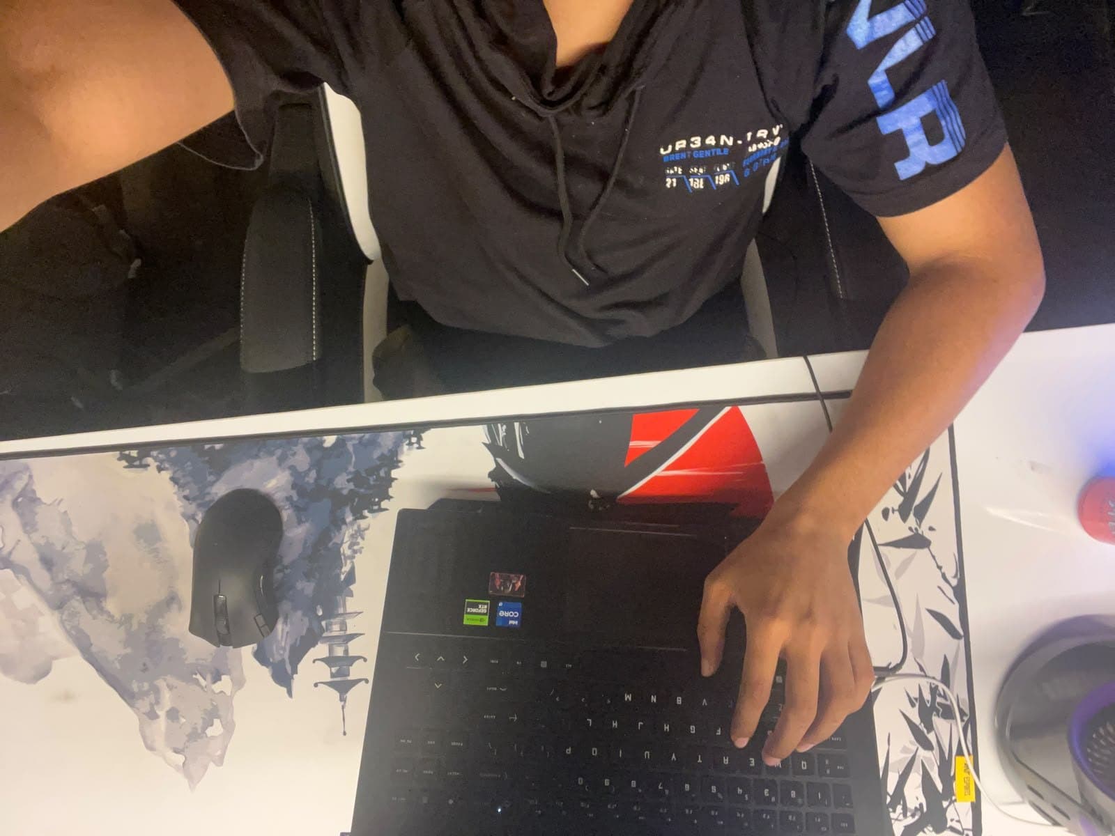 Top-down view of Prathith typing on a laptop at the desk